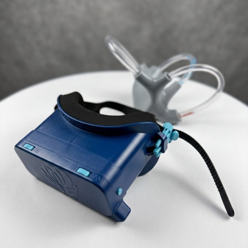 Navy blue infrared video goggles used for vestibular assessment, resting on a white table